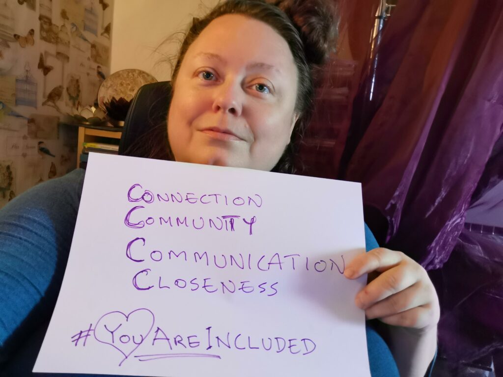 Person holding up sign with the text: connection, community, communication, closeness, #YouAreIncluded